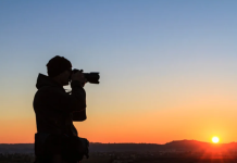 Fotografie op reis? Dit wil je weten! man fotografeert bij zonsondergang